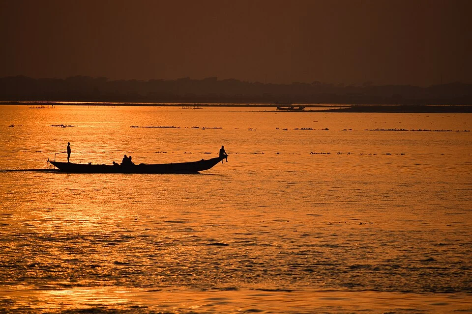 The vast expanse of the Padma River at the Chandpur estuary, showing the confluence of major rivers and traditional wooden boats.