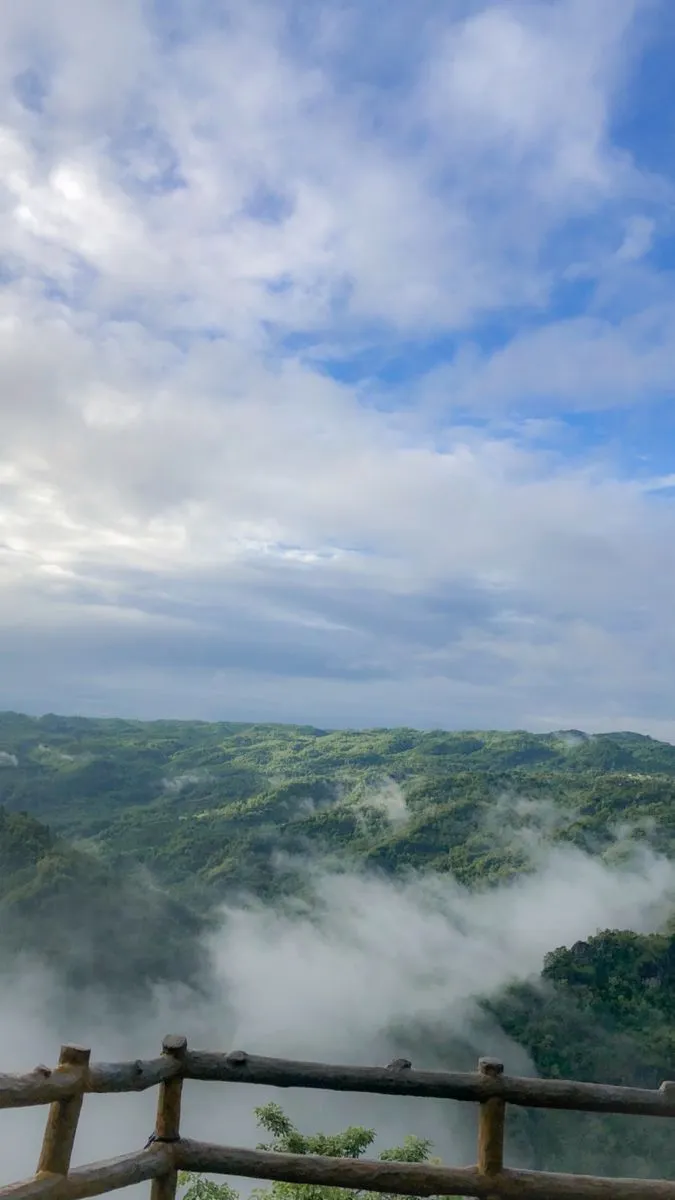 High-altitude view from Nilgiri, Bandarban, featuring a mountain resort above the clouds with a panoramic view of the horizon.